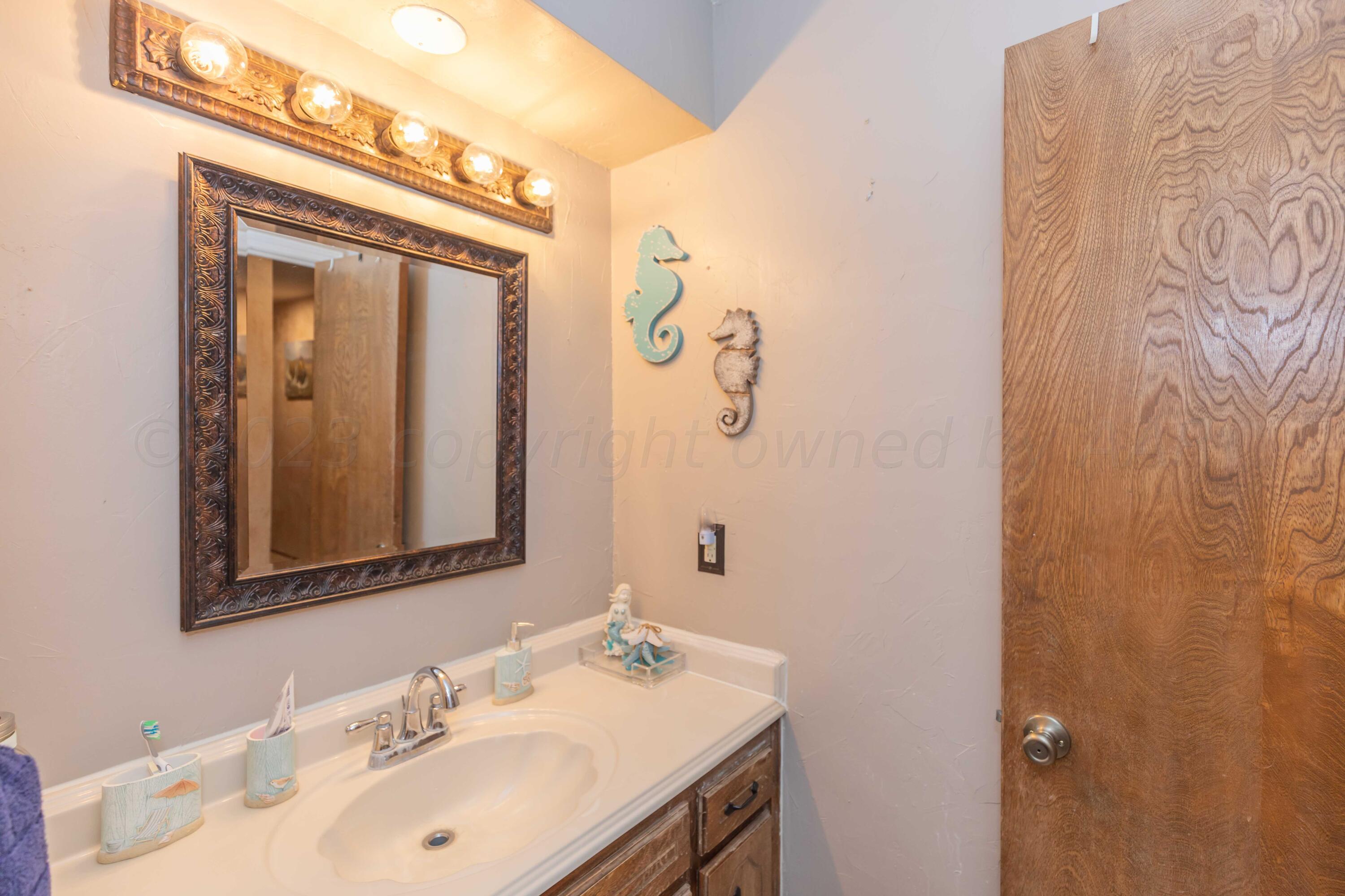 2805 Shield Court Amarillo, TX 79110 - Photo 25 of 36 a bathroom with a sink vanity and a mirror
