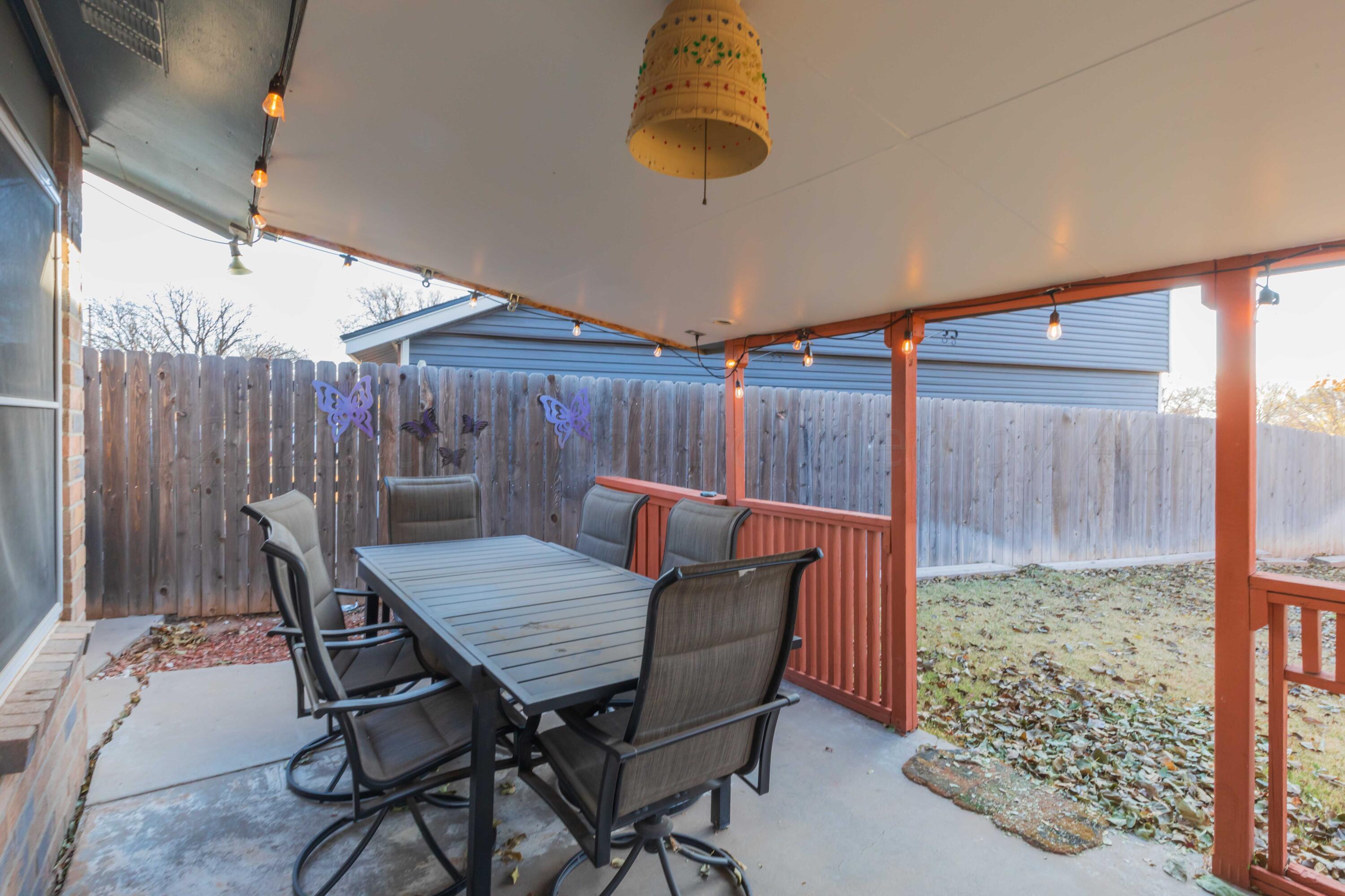 2805 Shield Court Amarillo, TX 79110 - Photo 32 of 36 a view of a patio with table and chairs with wooden floor and fence