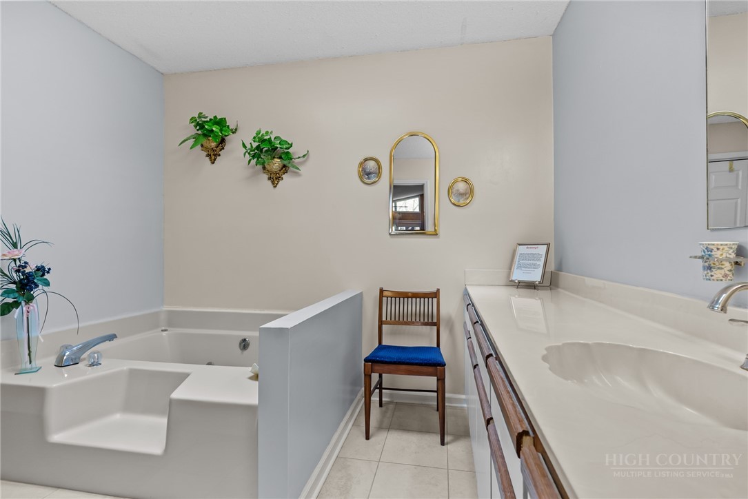 271 Quail Hollow Road Crumpler, NC 28617 - Photo 24 of 30 a bathroom with a bathtub sink and mirror