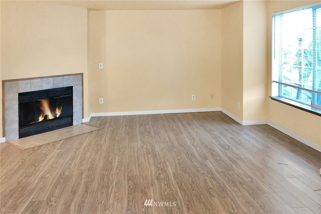 3118 Morrison Road West, Unit AD University Place, WA 98466 - Photo 3 of 11 a view of an empty room with wooden floor fireplace and a window
