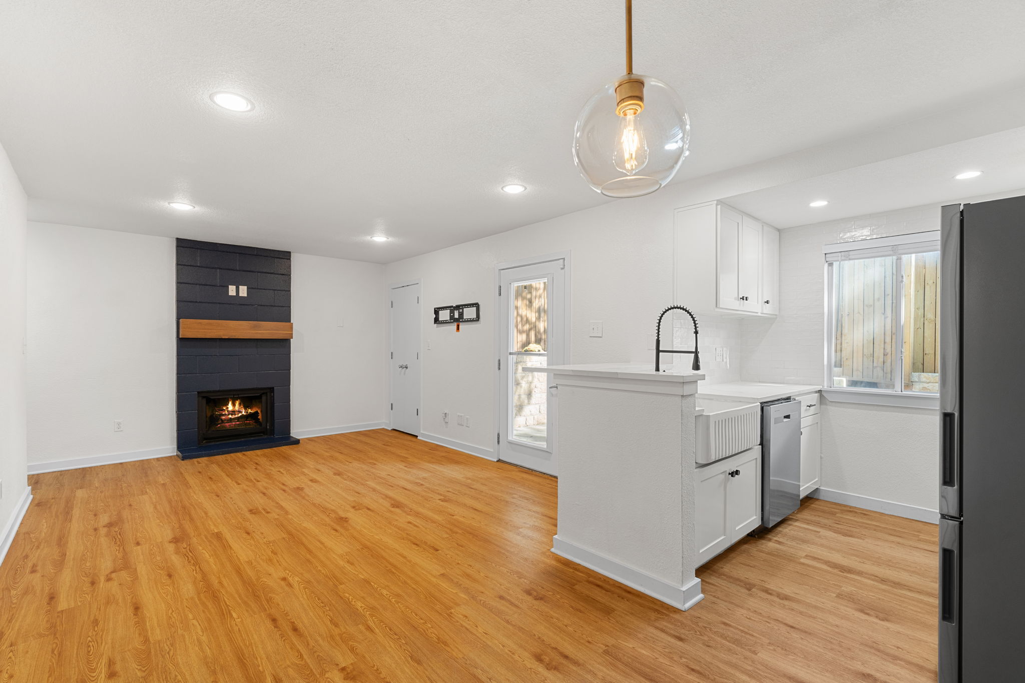 3601 Menchaca Road, Unit 110 Austin, TX 78704 - Photo 1 of 1 A vibrant living space with rich hardwood floors and a modern fireplace, perfect for intimate gatherings.