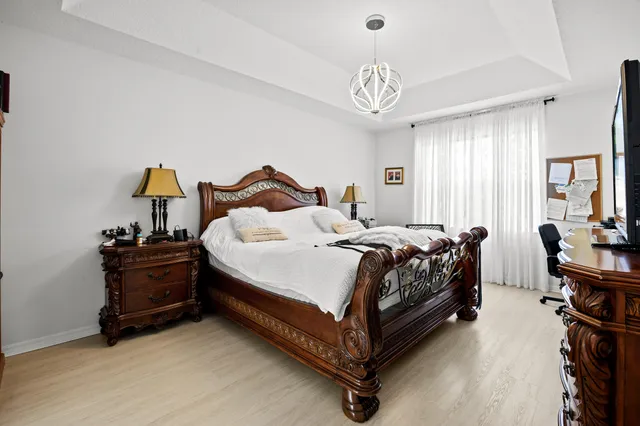 a spacious bedroom with a bed and a chandelier