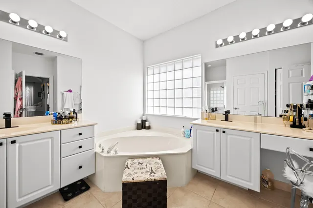 a spacious bathroom with 2 sink tub and a mirror