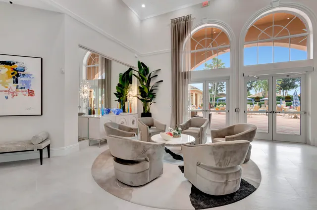 a living room with couches a fireplace and a large mirror with potted plants