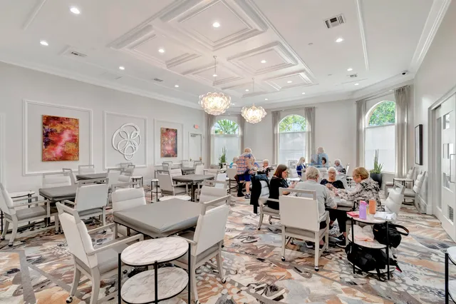 a living room with lots of furniture a rug and a chandelier