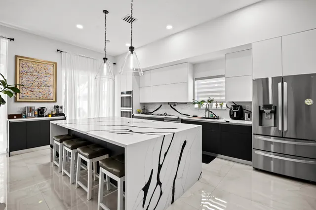 a kitchen with a center island a sink stainless steel appliances and cabinets