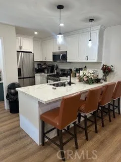 a kitchen with a dining table chairs refrigerator and microwave