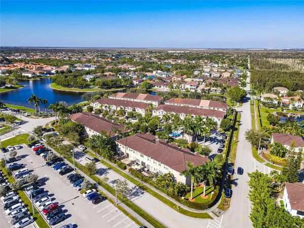 an aerial view of a city with lots of residential buildings ocean and mountain view in back