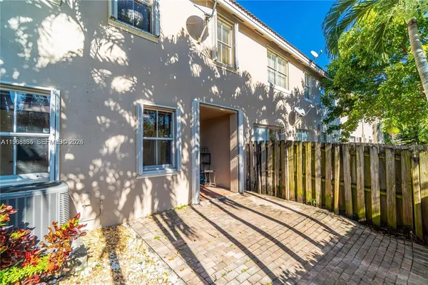 a view of a house with a large tree and wooden fence