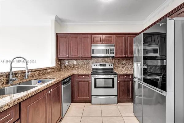 a kitchen with stainless steel appliances granite countertop a refrigerator and a sink