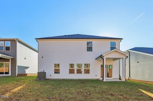 a view of an house with backyard and a porch