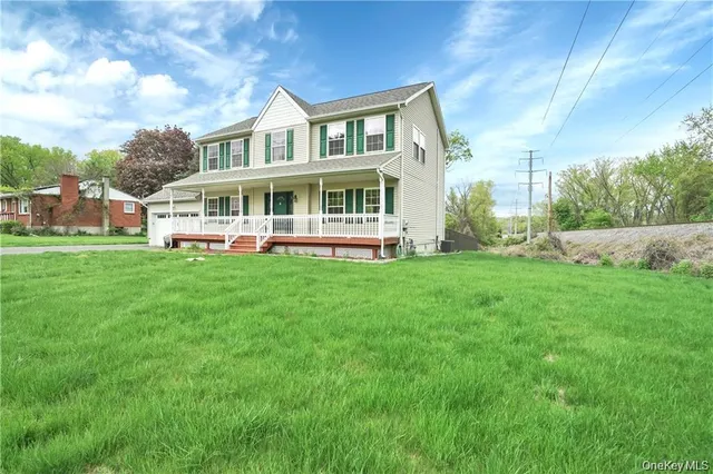 a view of a house with a big yard and sitting area