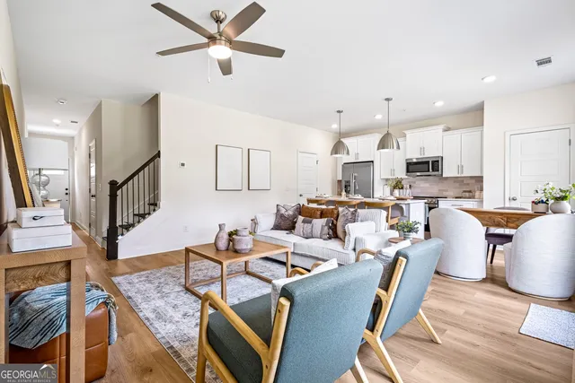 a living room with lots of furniture and kitchen view
