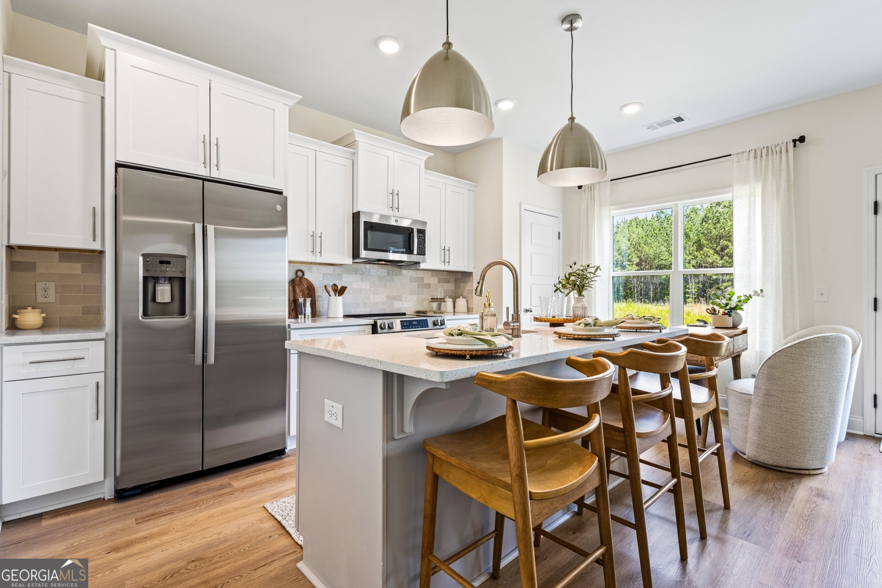 205 Starr Circle Stockbridge, GA 30281 - Photo 8 of 30 a kitchen with stainless steel appliances granite countertop a stove a refrigerator a oven a sink a island with a dining table and chairs