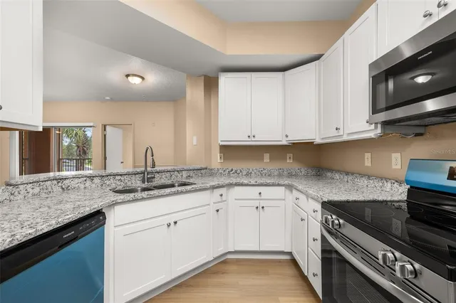 a kitchen with granite countertop white cabinets and a sink