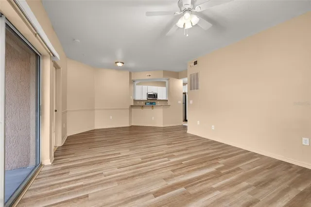 an empty room with fan and windows