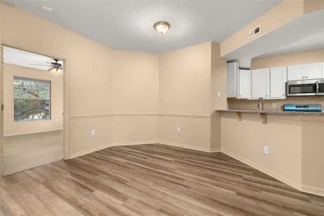 a view of an empty room and window and a ceiling fan
