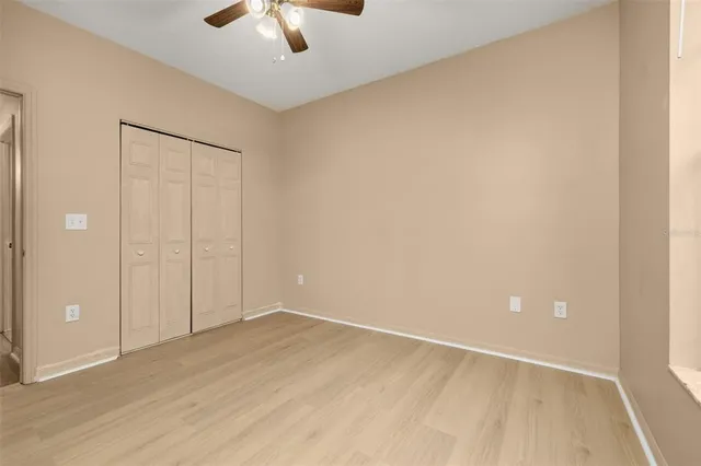 an empty room with a window and a fan
