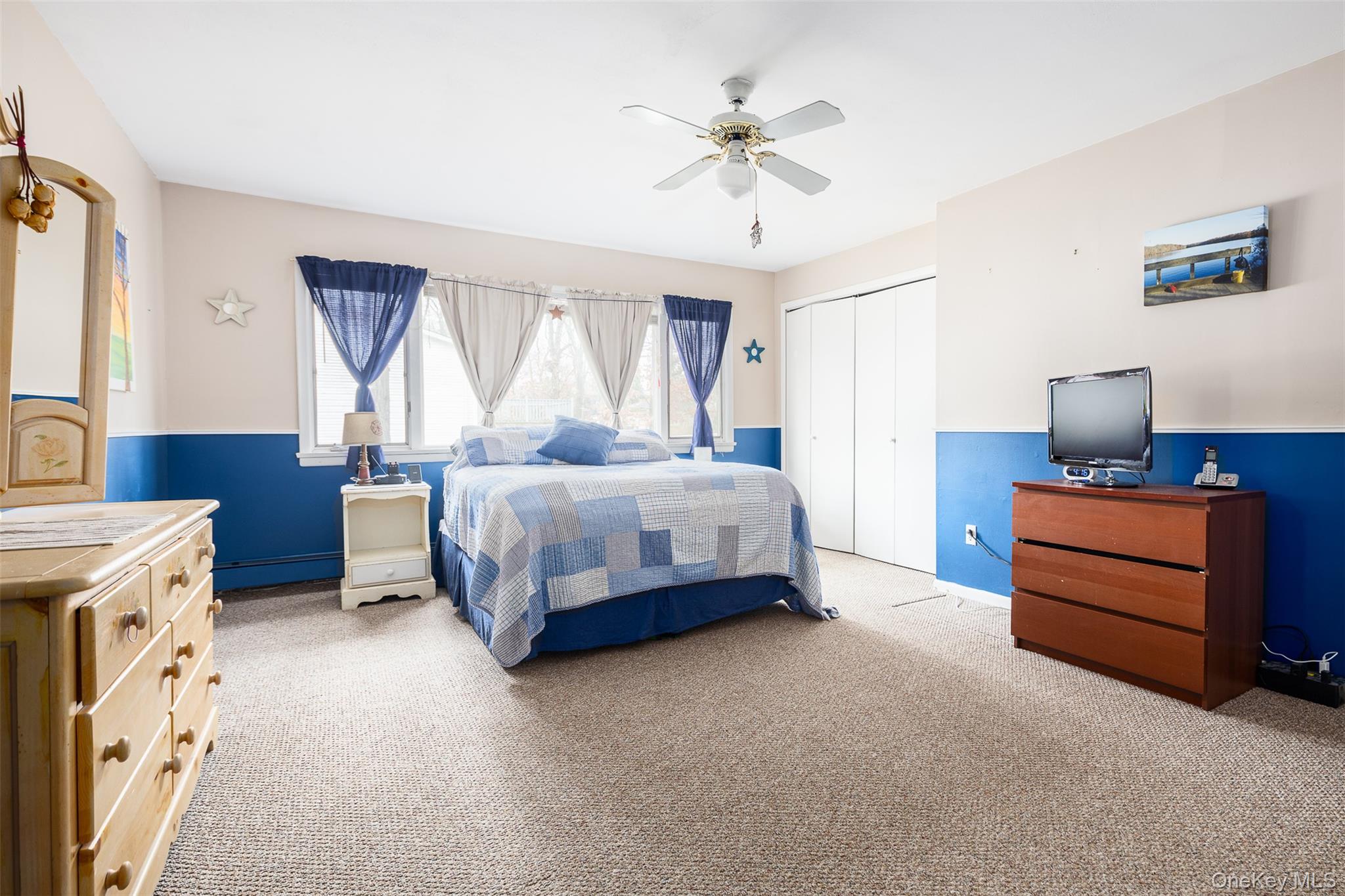 2 Fenwick Street Mastic, NY 11950 - Photo 7 of 27 a bedroom with a bed and a chandelier