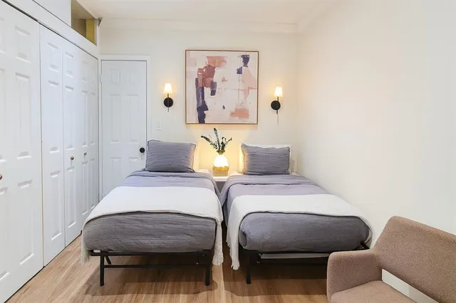 a bedroom with bed and wooden floor