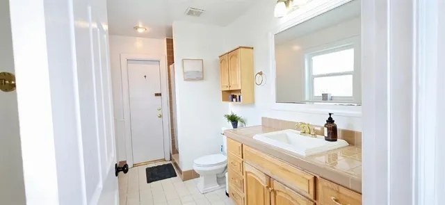 a bathroom with a sink a toilet and a mirror