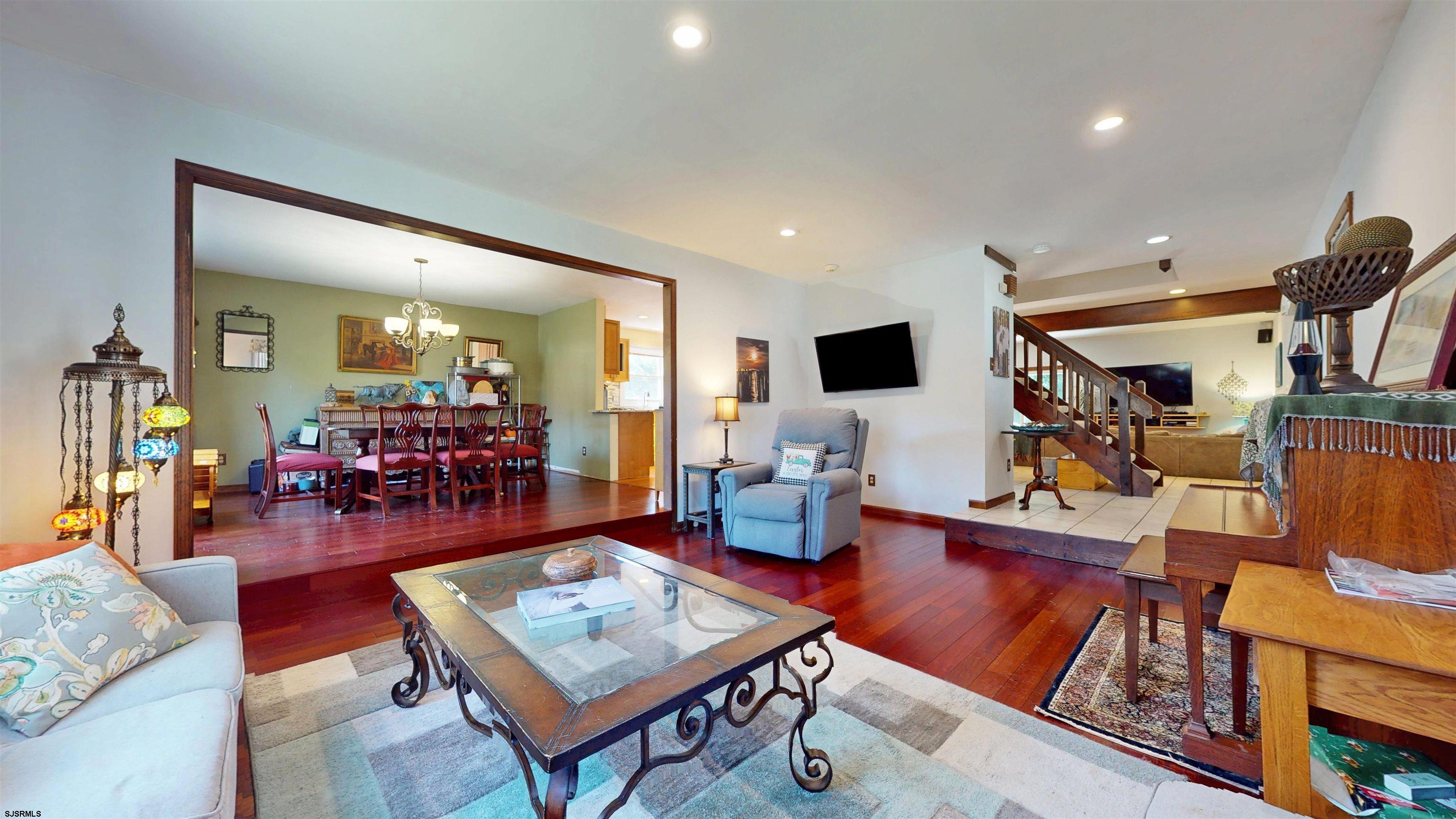 7 Woodstock Linwood, NJ 08221 - Photo 17 of 60 a living room with furniture a flat screen tv and a dining table with wooden floor