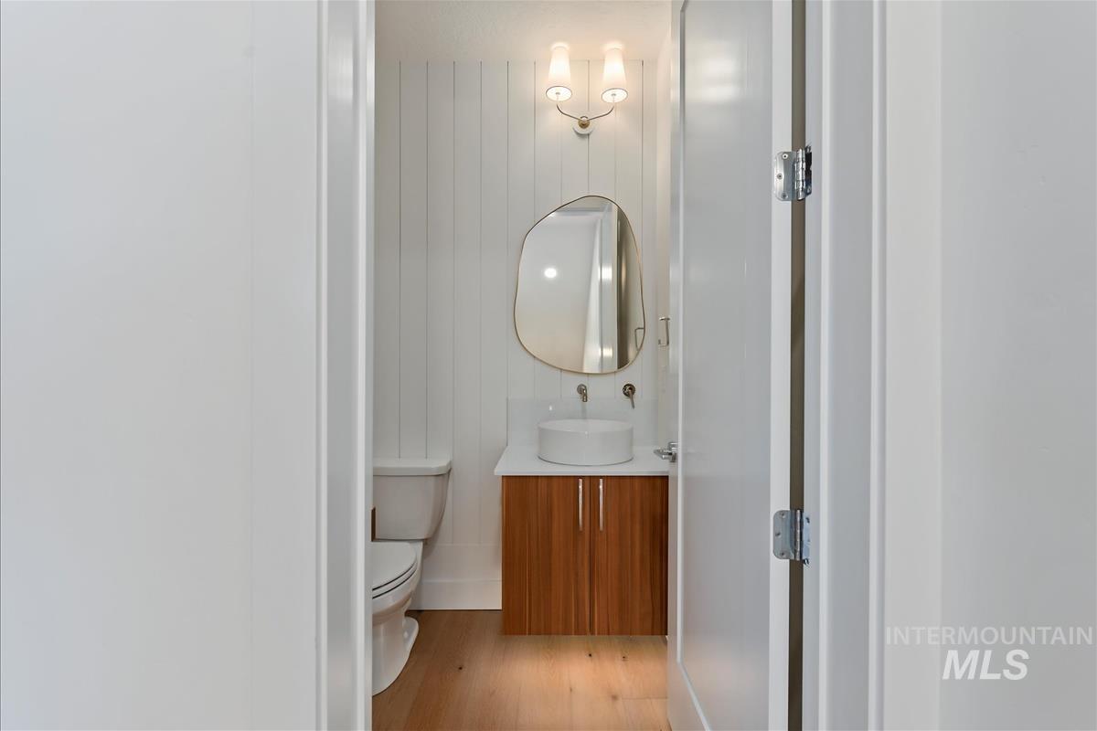 3213 West Moore Street Boise, ID 83702 - Photo 16 of 32 Bathroom featuring a wall-mounted vanity with a vessel sink, wood-finish cabinetry, and light wood-finish flooring