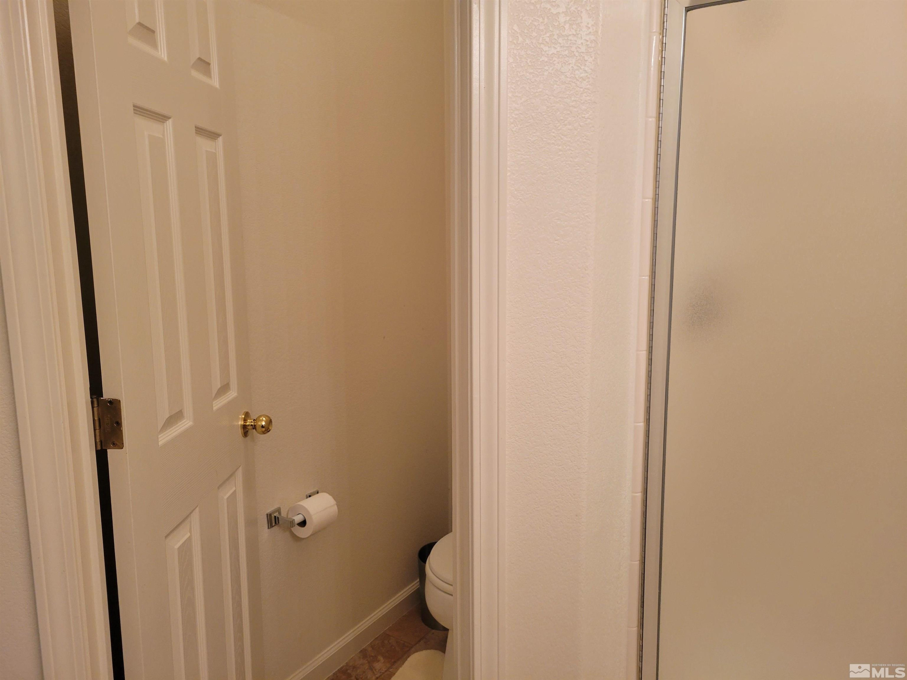 10415 Summershade Lane Reno, NV 89521 - Photo 13 of 15 a bathroom with a granite countertop toilet and a shower