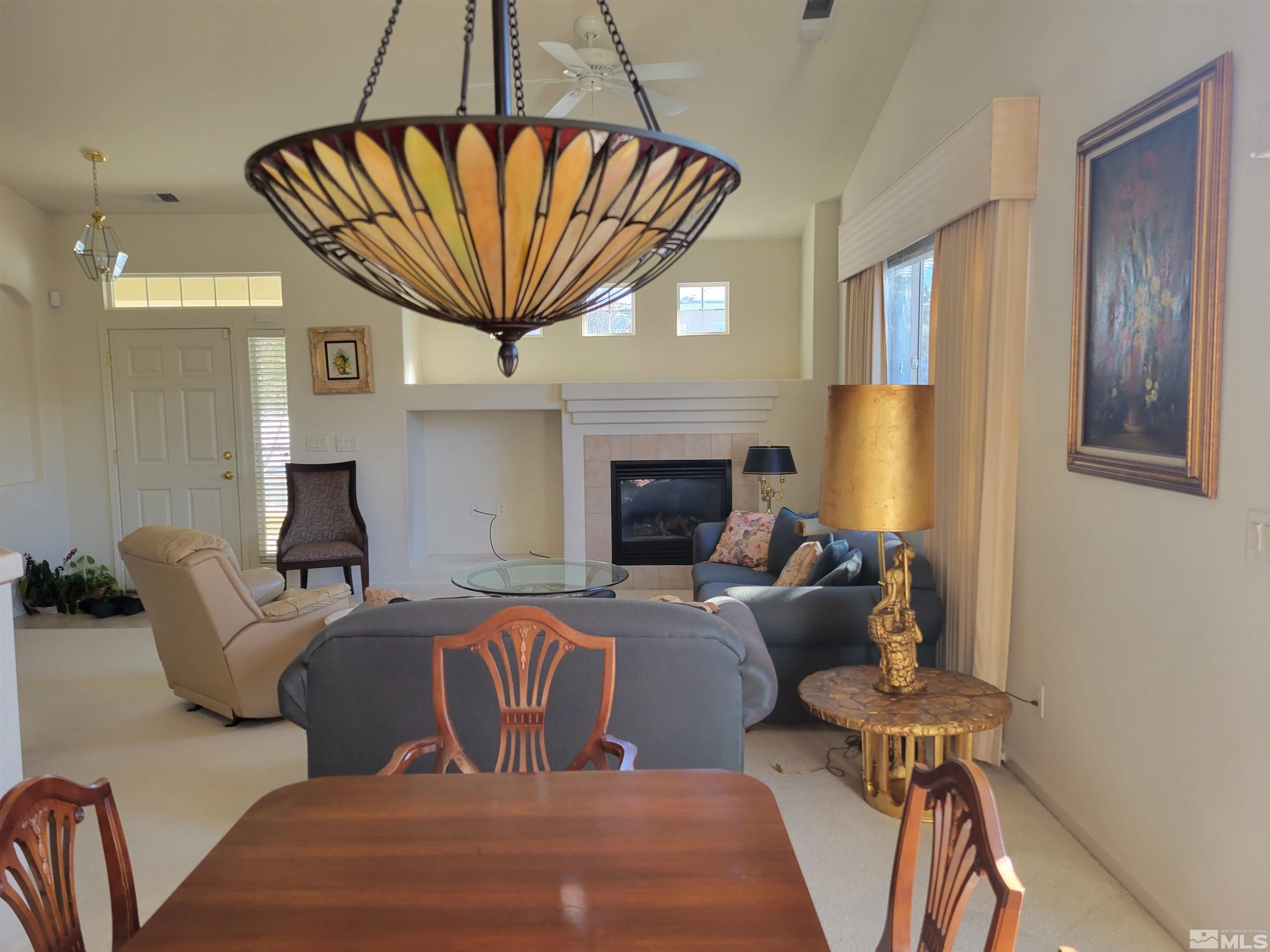 10415 Summershade Lane Reno, NV 89521 - Photo 8 of 15 a living room with furniture a fireplace and a chandelier