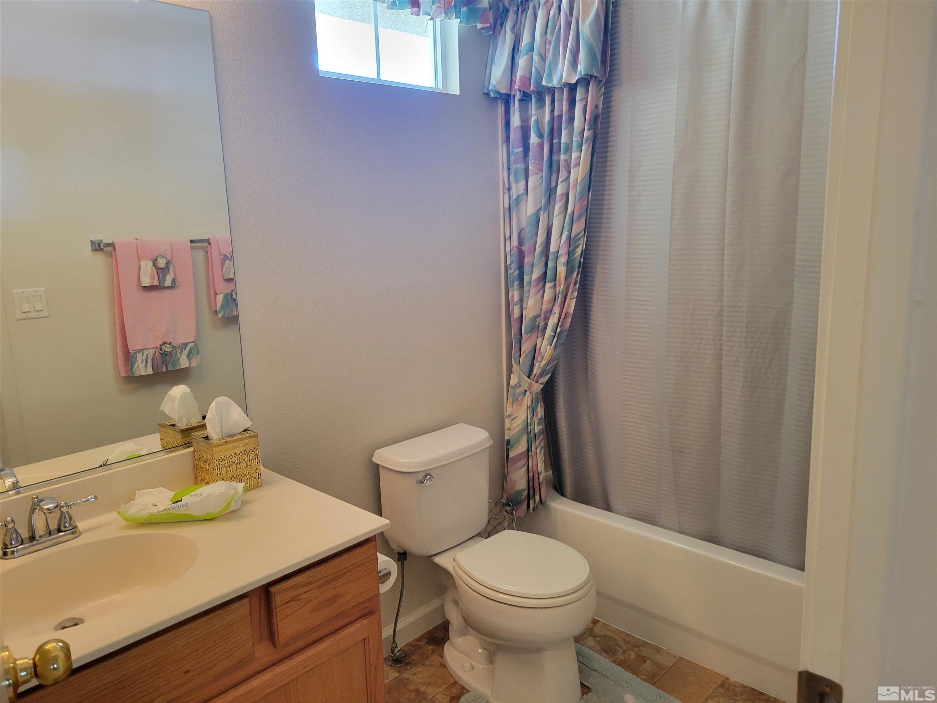 10415 Summershade Lane Reno, NV 89521 - Photo 9 of 15 a bathroom with a sink a toilet and shower curtain