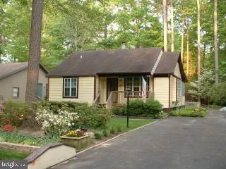 165 Sandyhook Road Ocean Pines, MD 21811 - Photo 1 of 4 a front view of a house with a yard and potted plants