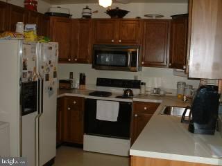 165 Sandyhook Road Ocean Pines, MD 21811 - Photo 2 of 4 a kitchen with a refrigerator and a stove top oven