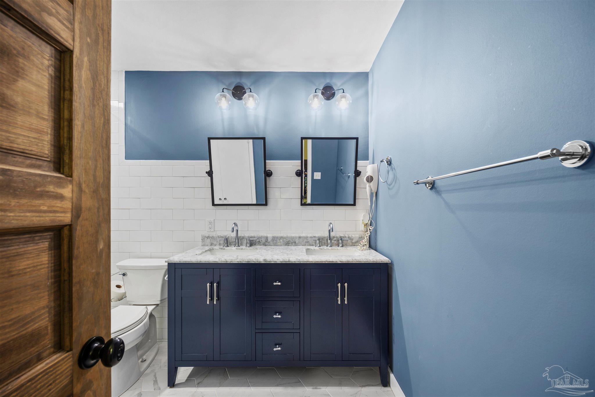 4067 Parkview Street Pace, FL 32571 - Photo 13 of 46 a bathroom with a double vanity sink and mirror