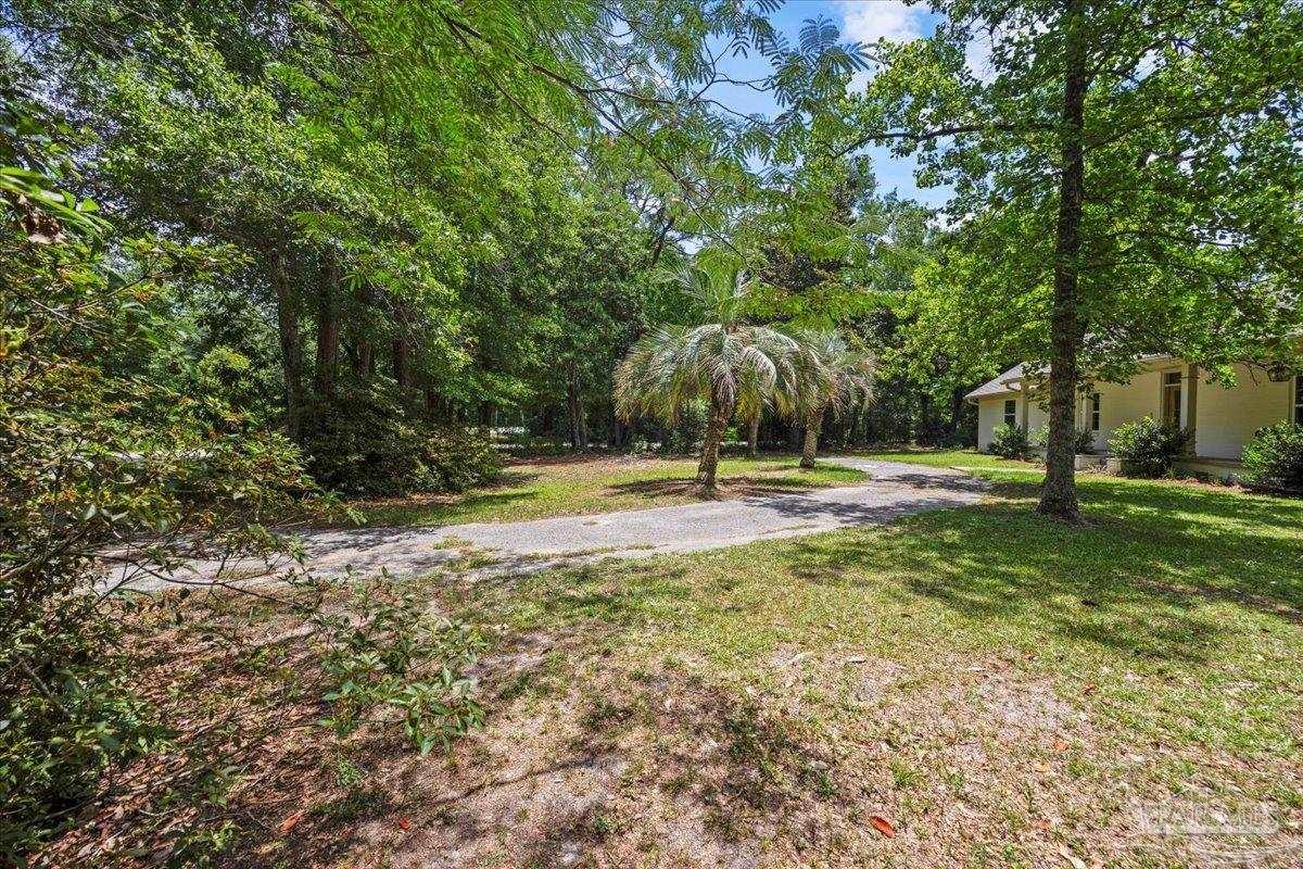 4067 Parkview Street Pace, FL 32571 - Photo 37 of 46 a swimming pool with outdoor seating and yard