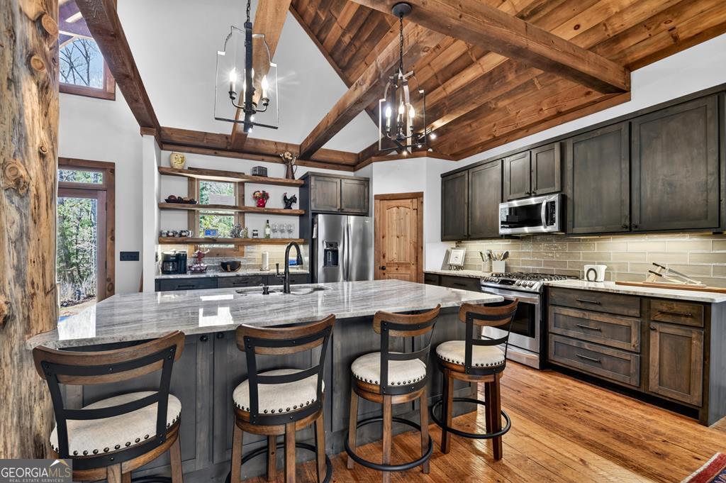 366 Shepherds Lane Morganton, GA 30560 - Photo 28 of 79 a kitchen with stainless steel appliances granite countertop a stove a sink dishwasher a dining table and chairs with wooden floor