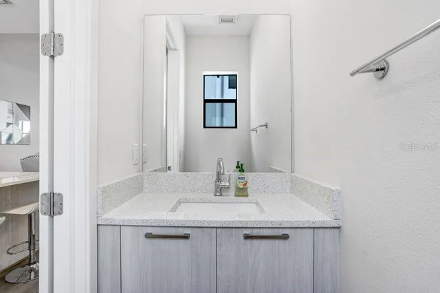 a bathroom with a granite countertop sink and a mirror