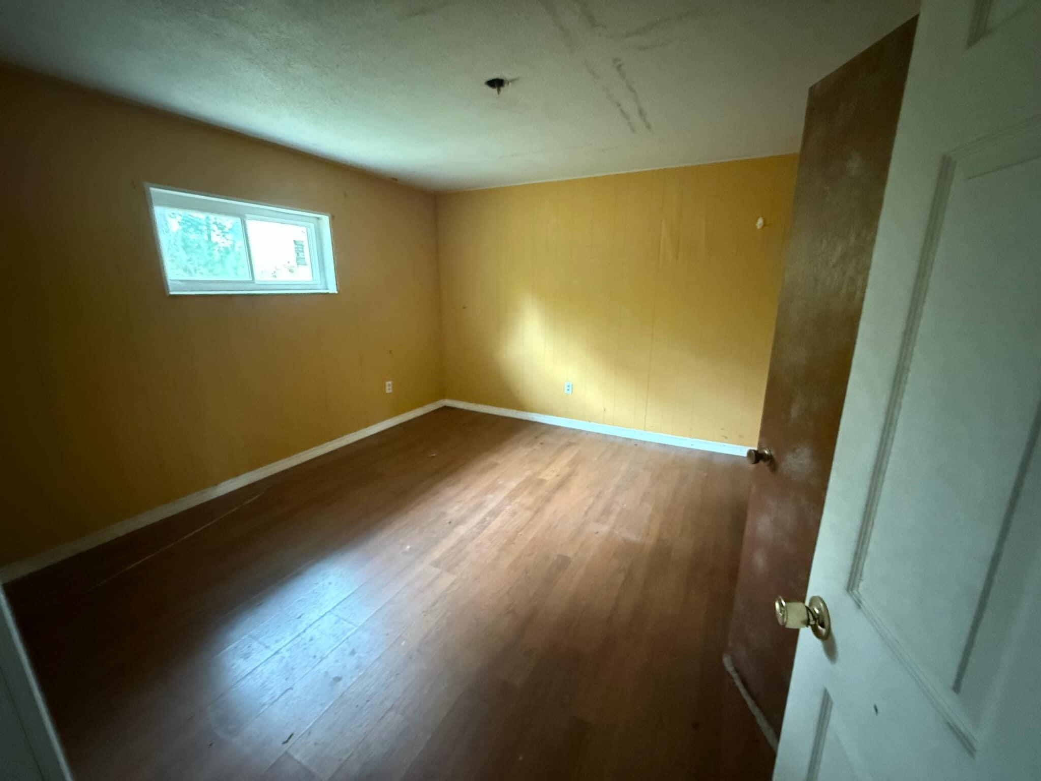 1951 Caton Road Florala, AL 36442 - Photo 22 of 34 an empty room with wooden floor and windows
