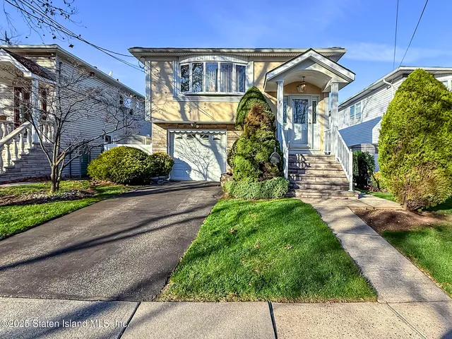 a front view of a house with a yard and potted plants