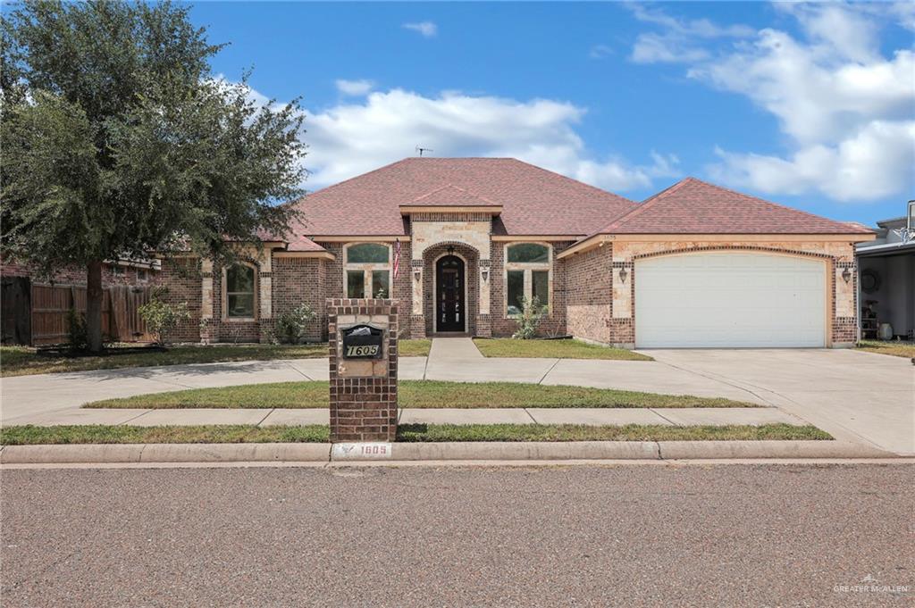 French country home featuring driveway, brick siding, an attached garage, and a shingled roof