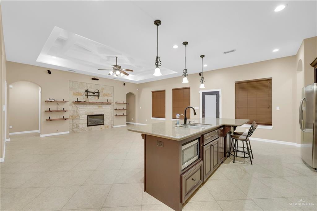 1605 East 30th Street Mission, TX 78574 - Photo 2 of 16 Kitchen featuring arched walkways, a kitchen bar, a raised ceiling, decorative light fixtures, and recessed lighting