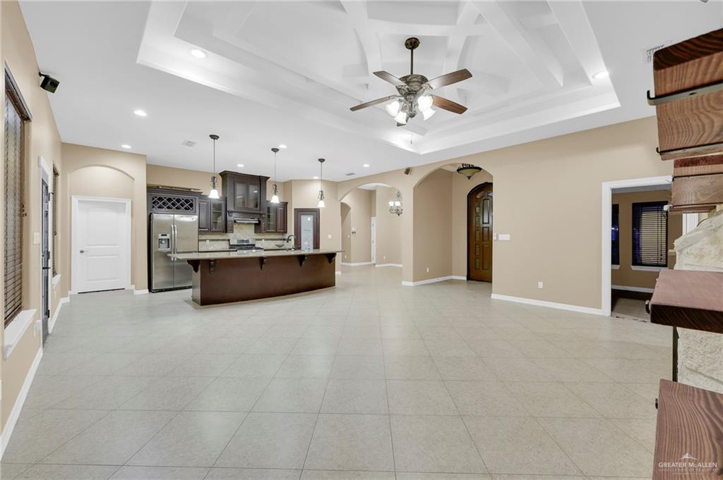 1605 East 30th Street Mission, TX 78574 - Photo 15 of 16 Kitchen with glass insert cabinets, a breakfast bar, open floor plan, appliances with stainless steel finishes, and arched walkways
