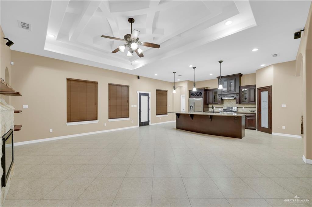1605 East 30th Street Mission, TX 78574 - Photo 16 of 16 Kitchen featuring open floor plan, a breakfast bar, glass insert cabinets, decorative backsplash, and recessed lighting