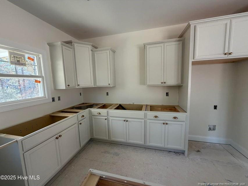2177 Airport Road Whispering Pines, NC 28327 - Photo 6 of 15 a kitchen with white cabinets and sink