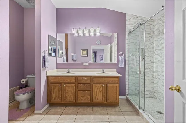 a spacious bathroom with a granite countertop sink a toilet and a shower