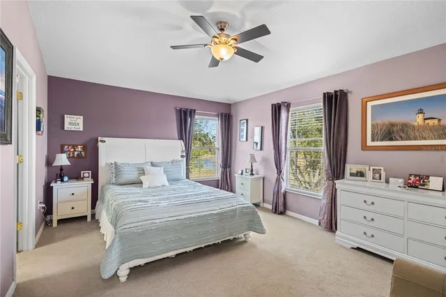 a bedroom with a bed and a chandelier fan