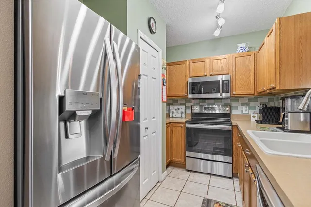 a kitchen with stainless steel appliances a refrigerator sink and microwave