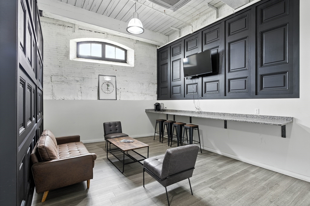 55 Sterling Street, Unit 306 Clinton, MA 01510 - Photo 21 of 32 a living room with furniture a flat screen tv and kitchen view