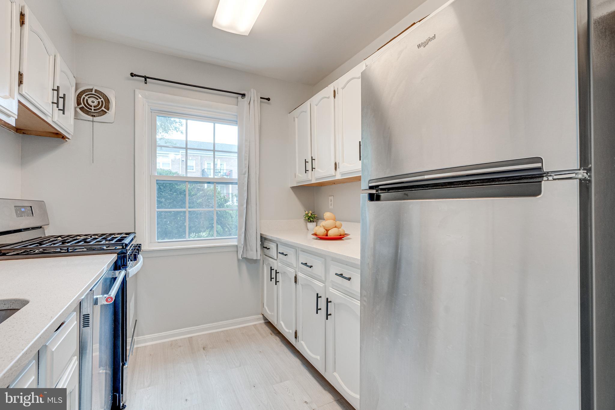 9473 Fairfax Boulevard, Unit 104 Fairfax, VA 22031 - Photo 11 of 32 a kitchen with stainless steel appliances a refrigerator sink and cabinets
