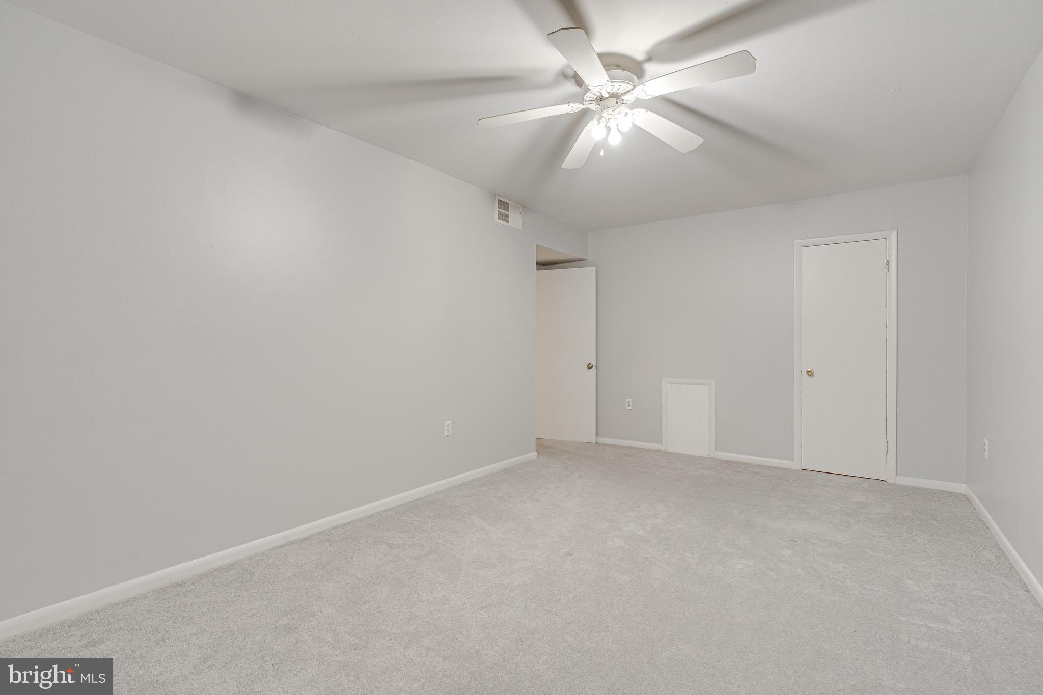 9473 Fairfax Boulevard, Unit 104 Fairfax, VA 22031 - Photo 15 of 32 an empty room with a chandelier fan and windows