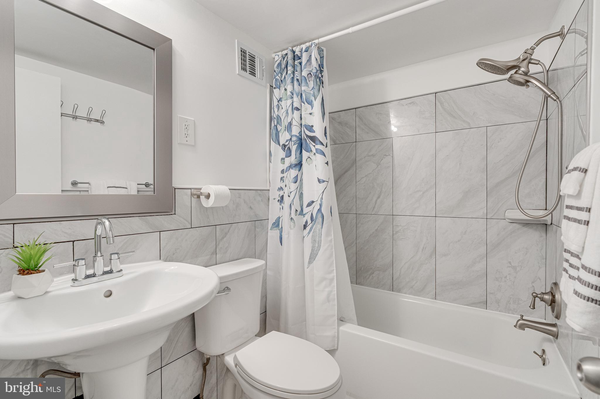 9473 Fairfax Boulevard, Unit 104 Fairfax, VA 22031 - Photo 21 of 32 a bathroom with a sink a toilet and shower